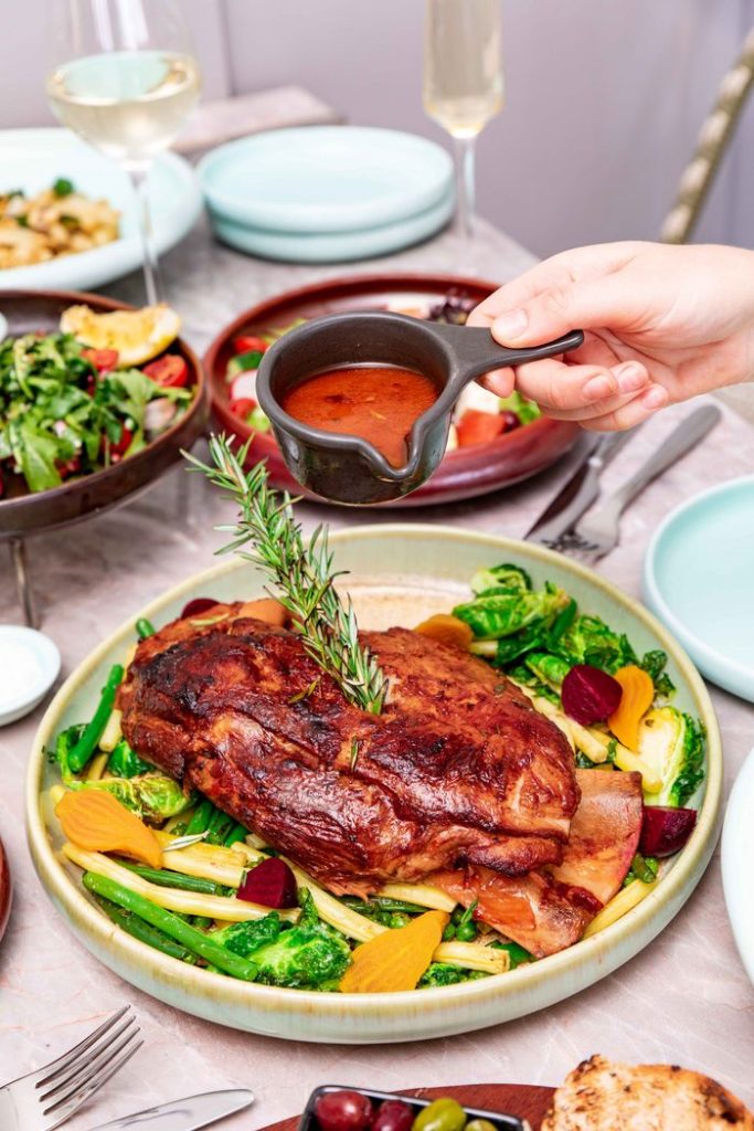 Delicious roast meat served with fresh vegetables and rich sauce. Ideal for festive dining settings.